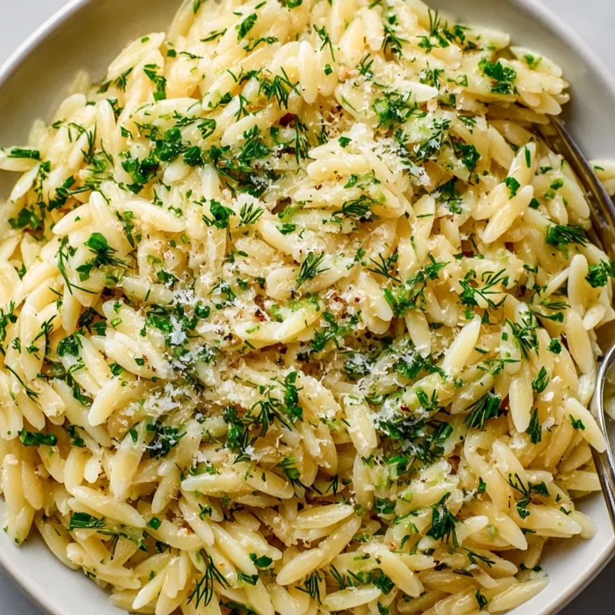 Creamy herb butter orzo, a vibrantly green and golden side dish, garnished with fresh herbs.