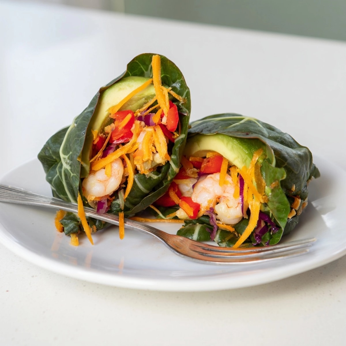 Easy recipe for low-carb lunch: Shrimp & Cheddar Collard Green Wraps, sliced in half.