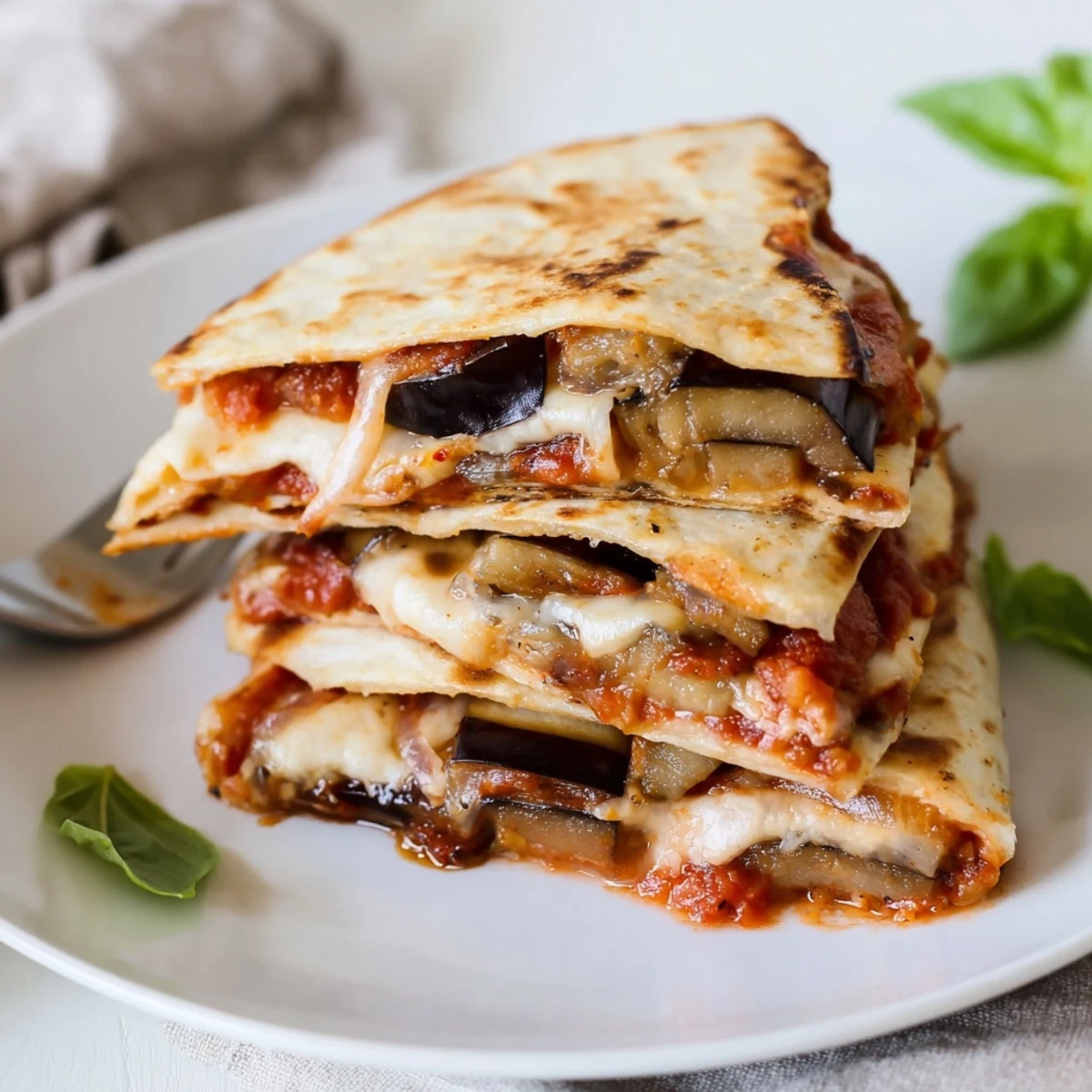 Delicious Cheesy Eggplant Parmesan Quesadillas served with fresh basil for added flavor.