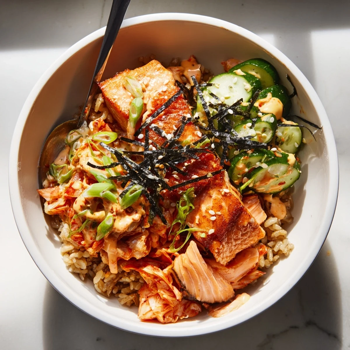 Flavorful Crispy Salmon Rice Bowl garnished with garlic, scallions, and savory sesame seeds.