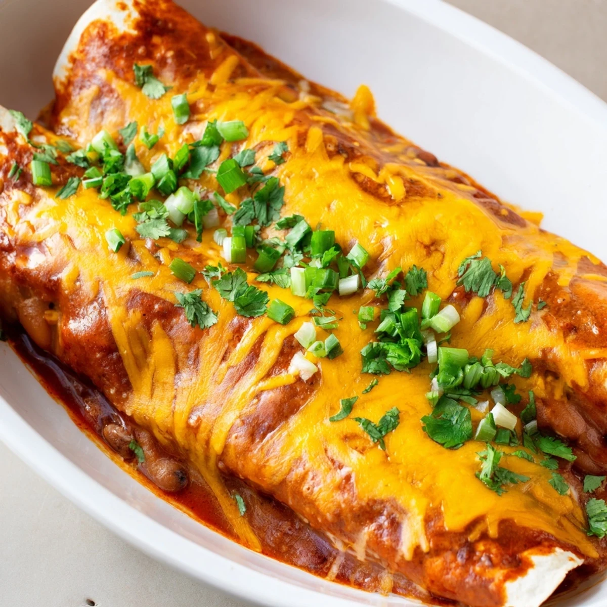 Enjoy flavorful, homemade Cheesy Bean Enchiladas, a vegetarian delight with a rich, savory filling.