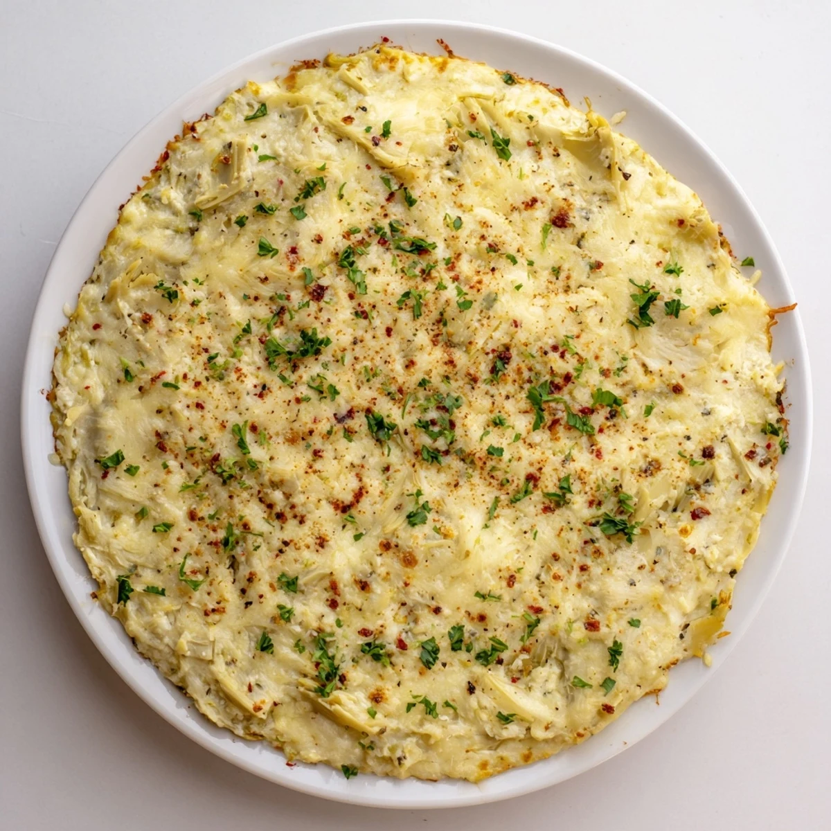 Warm, bubbly Baked Artichoke Dip, creamy and golden brown, ready for dipping and sharing.