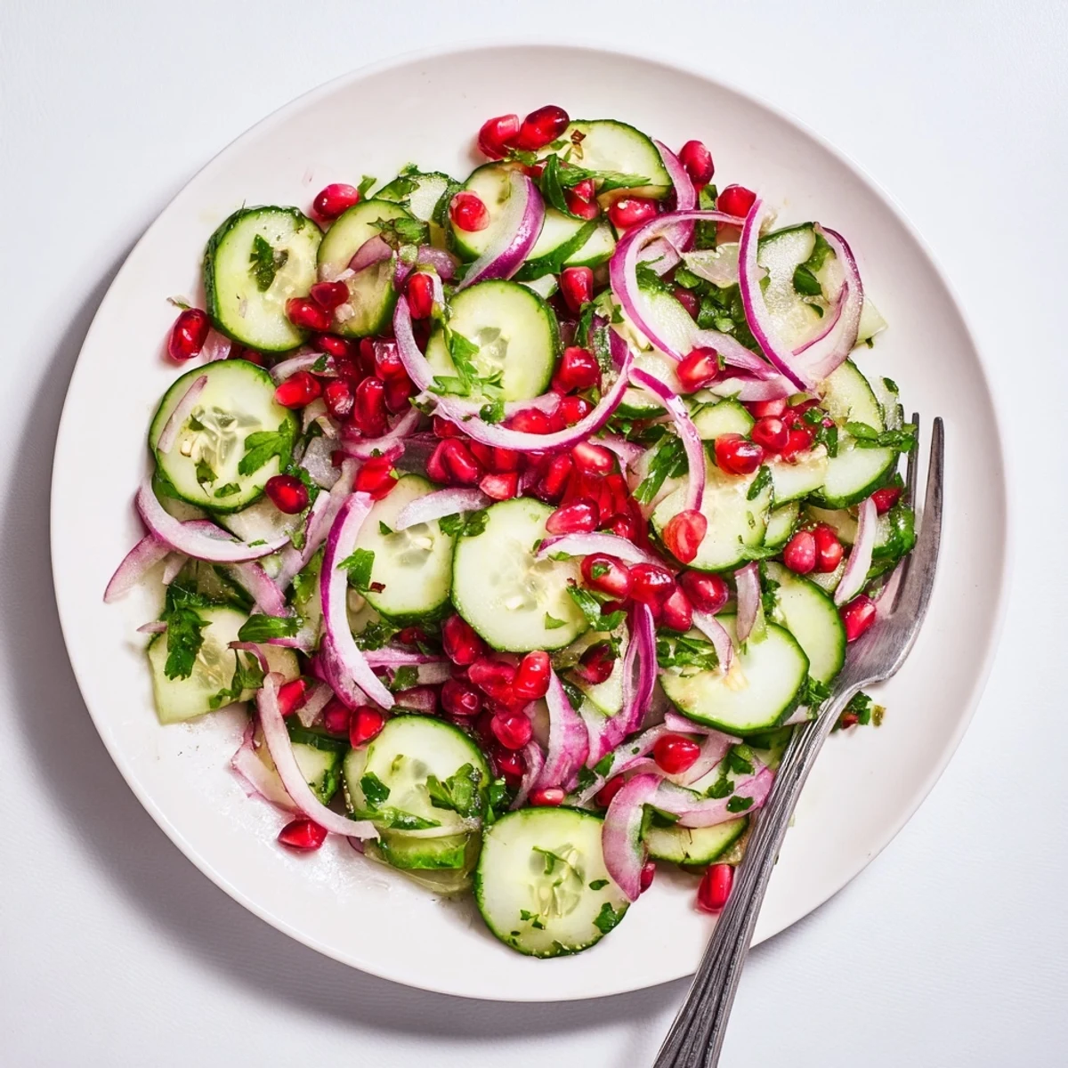 Healthy Cucumber Christmas Salad, a vibrant mix of cucumbers, pomegranate, and citrus dressing ready to serve.