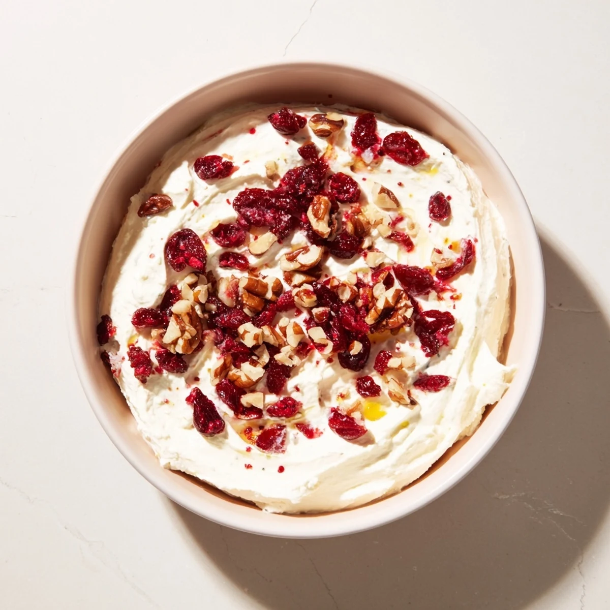 A close-up of lightened holiday cream cheese dip, a creamy appetizer with cranberry and herbs.