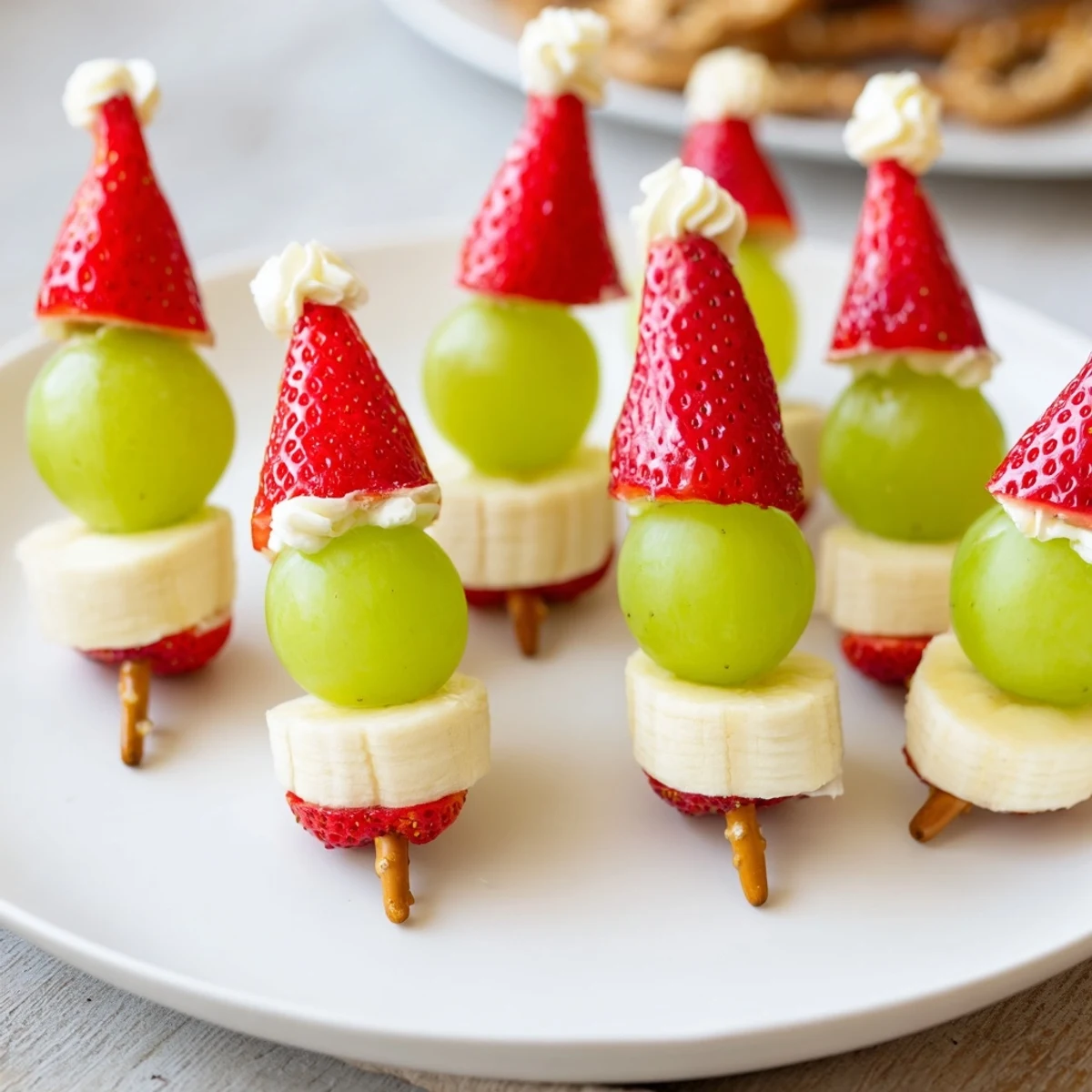 Vibrant Elf Hat Strawberry Skewers showcase a playful, colorful fruit snack with banana and grape detail.