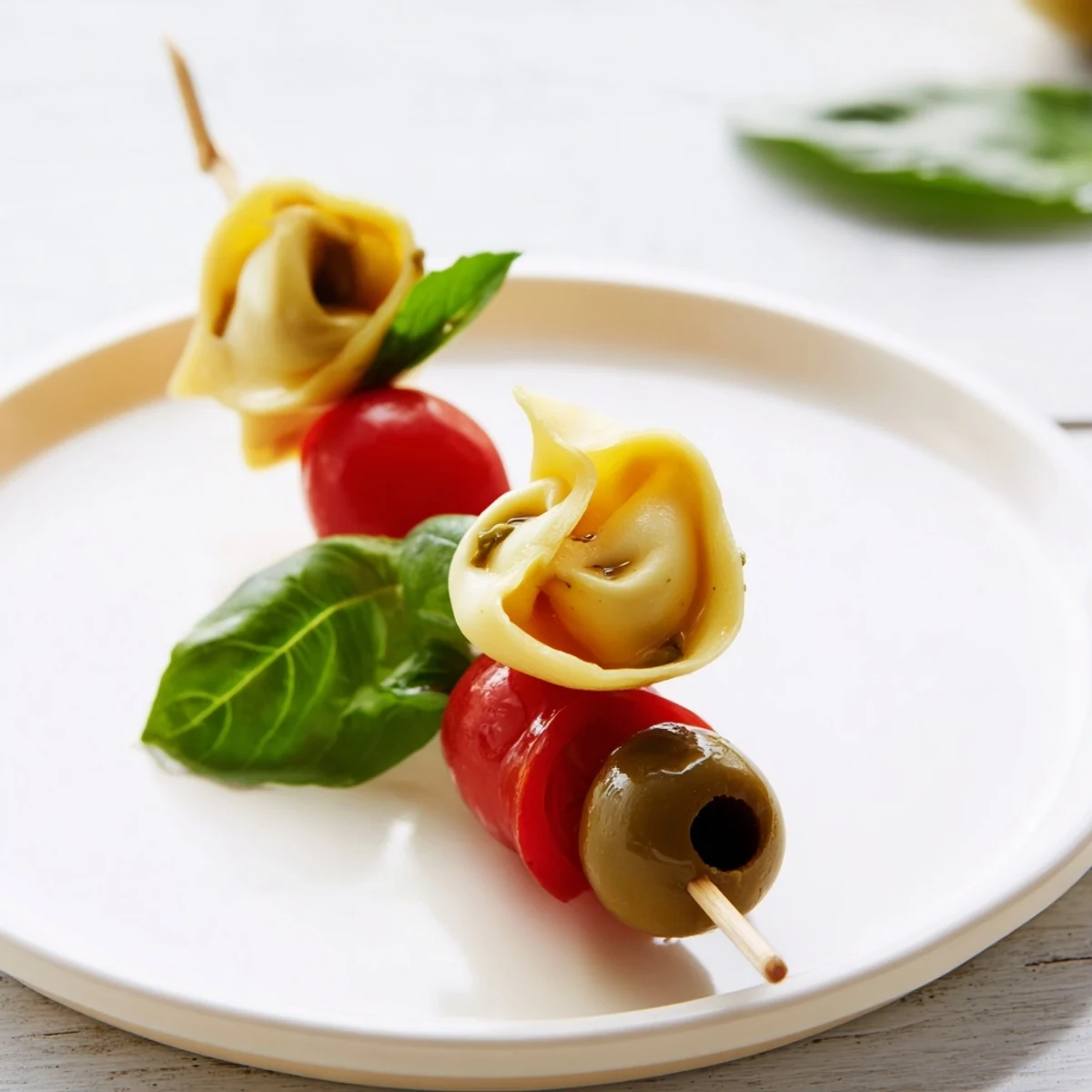 Delicious appetizer skewers featuring tortellini, pesto-covered and threaded alongside olives, perfect for a party.
