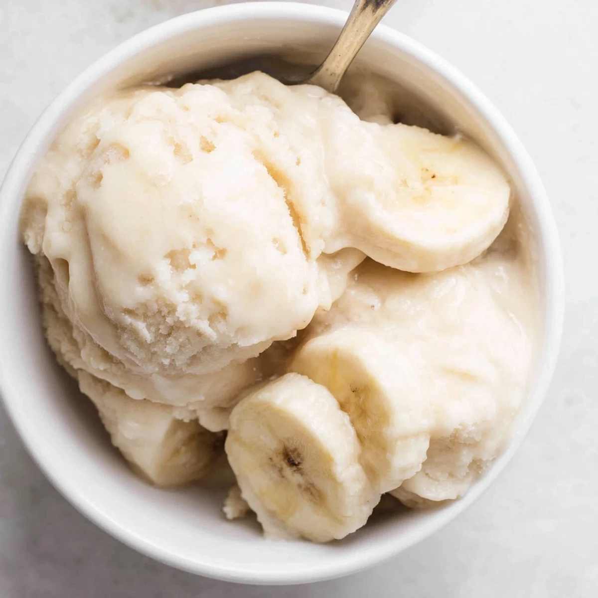 Freshly blended 2-Ingredient Banana Ice Cream, a vibrant, creamy dessert free of dairy or added sugars.
