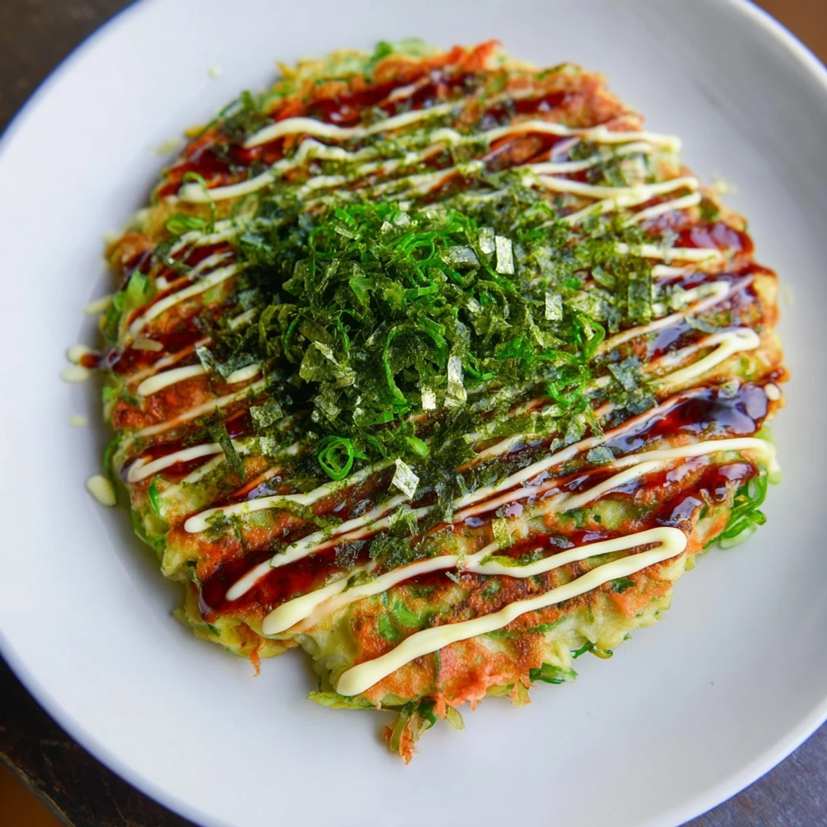 Close-up of a perfectly cooked Japanese okonomiyaki pancake, ready to be enjoyed as a savory meal.