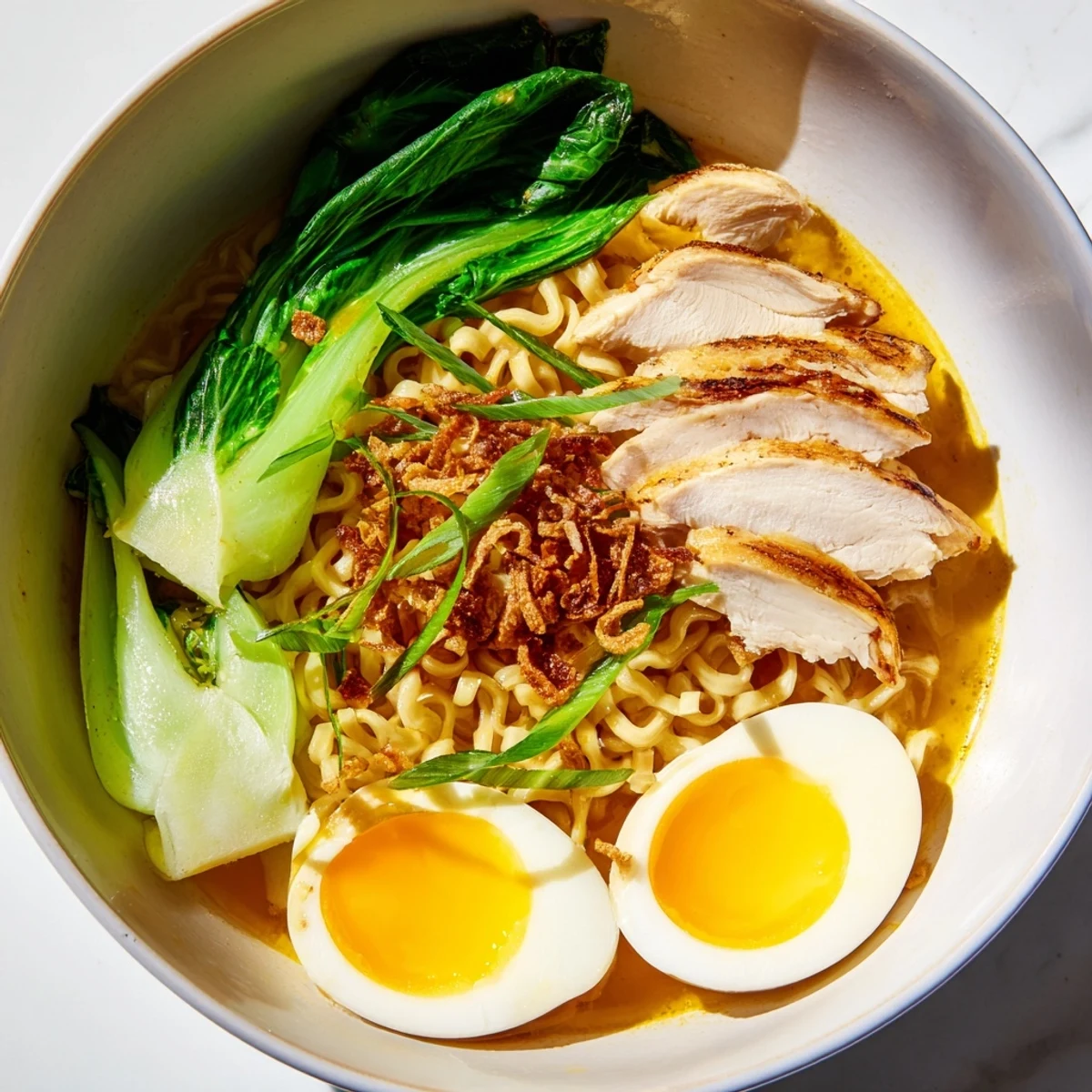 Steaming Thai miso ramen bowl with sliced chicken, vibrant bok choy, and soft-boiled egg halves.