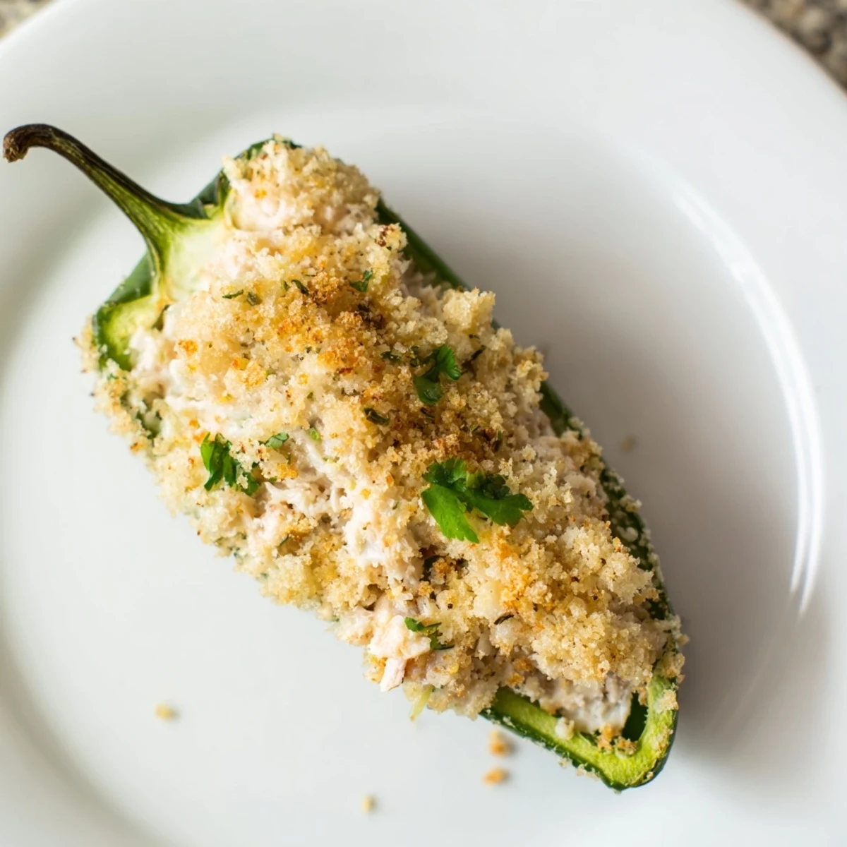Golden-brown Cajun Crab Poppers spill creamy lump crab filling from halved jalapeños, flecked with herbs and a buttery panko crust.