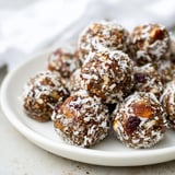 Spiced Holiday Snack Energy Balls rolled in coconut, ready to enjoy with warm cider.