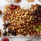 Sweet Caramel Popcorn Charcuterie Board piled high; perfect for sharing movie night treats.