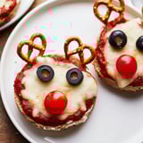 Homemade Reindeer Face Pizza Bagels feature melted cheese and pretzel antlers, perfect for kids.