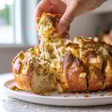 A person is taking a bite out of a piece of bread.