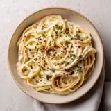 A bowl of pasta with red peppers and cheese.