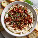 A white bowl filled with a red dip.