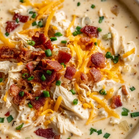 A bowl of soup with bacon and chicken.