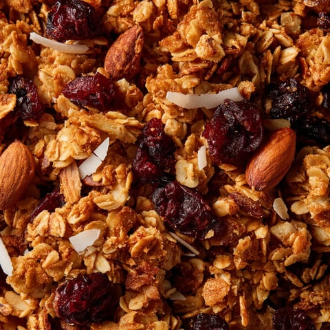 A close up of a granola cluster with cherries and almonds.