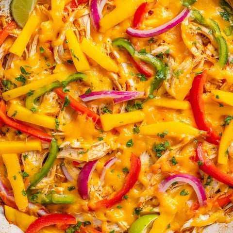 Savory mango chicken fajita casserole topped with melted cheese and fresh cilantro.  