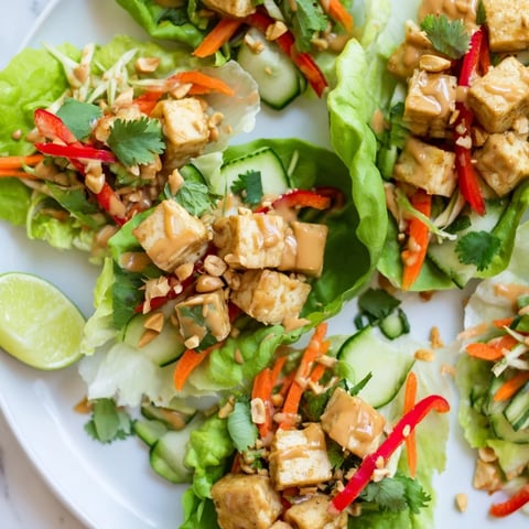 Crisp Thai Peanut Tofu Lettuce Wraps filled with fresh veggies and creamy sauce.  