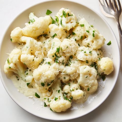 Creamy Alfredo cauliflower garlic skillet served hot, garnished with fresh parsley.  