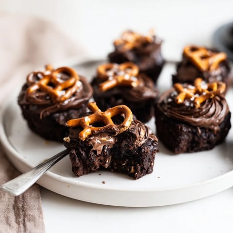 Fudgy Nutella Pretzel Brownie Bites topped with crunchy pretzels for a sweet-salty delight.  
