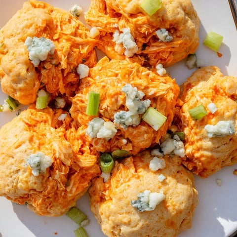 Fluffy Buffalo Chicken Soda Biscuits topped with blue cheese and scallions, ready to serve.  