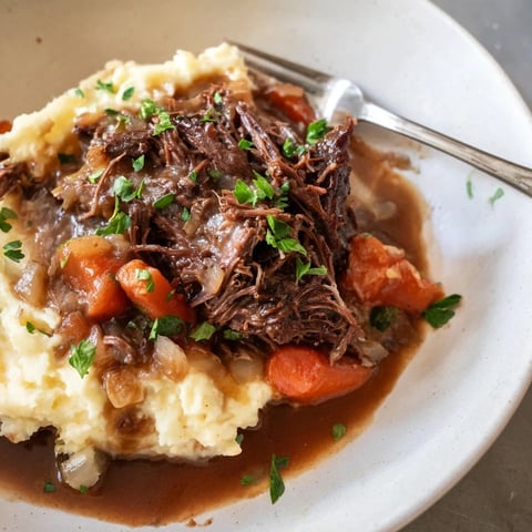 Slow Cooker Pot Roast with Mashed Potatoes served with rich gravy and fresh herbs.  