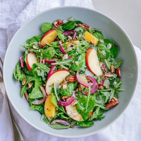 Crisp Apple Cider Vinaigrette Salad with Roasted Nuts drizzled in tangy dressing.  
