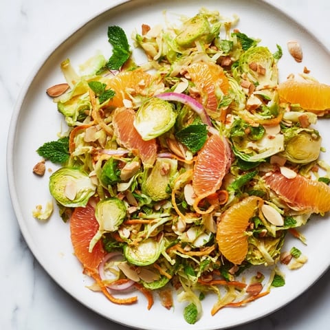 Sparkling Citrus Brussels Sprouts Slaw with colorful citrus segments and crunchy almonds, ready to serve.