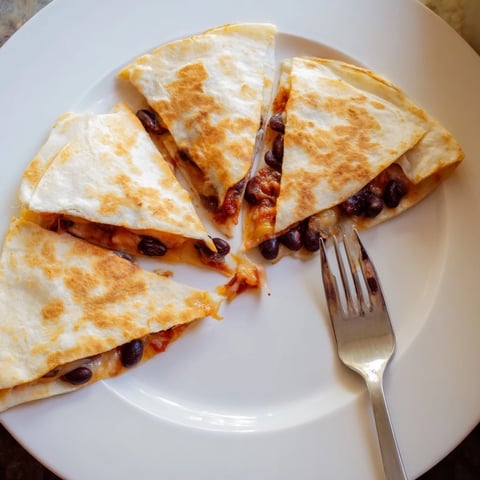 Golden-brown Bean & Cheese Quesadillas, a simple delight filled with melted cheese and flavorful beans.