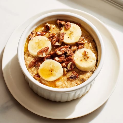 Golden baked oats ramekins with banana slices and sweet honey drizzle, a perfect breakfast.