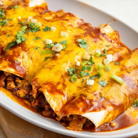 Steaming hot Cheesy Bean Enchiladas with bubbly, golden cheese, perfect for a cozy weeknight meal.