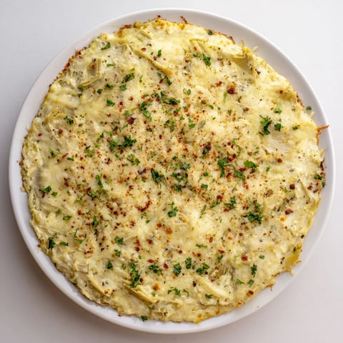 Warm, bubbly Baked Artichoke Dip, creamy and golden brown, ready for dipping and sharing.