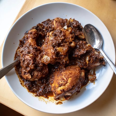 A comforting close-up showing a rich, dark Pomegranate Walnut Fesenjan stew, ready to serve.