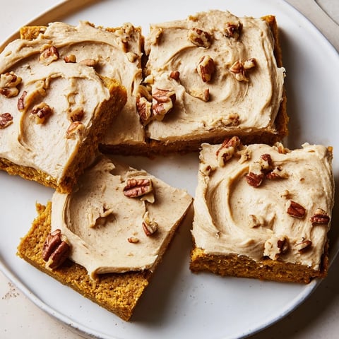 Warm and inviting image shows frosted Pumpkin Bars, perfect for a cozy autumn dessert.
