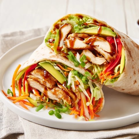 Tender teriyaki chicken wrap, bursting with colorful veggies and savory sauce, ready to enjoy.