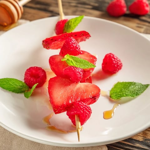 Vibrant Red Heart Fruit Skewers sparkle, displaying heart-shaped watermelon, strawberries, and raspberries ready to eat.