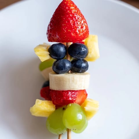 Vibrant Rocket Ship Fruit Skewers feature strawberries, pineapple, and grapes creating a visually appealing snack.