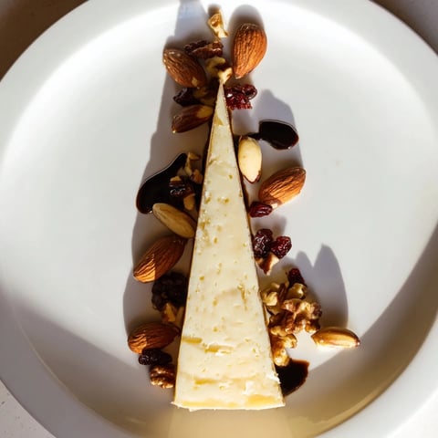 A sundial cheese platter with aged cheese "sun" and nut "hours," perfect for entertaining guests.