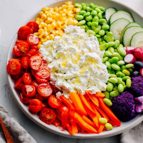 Vibrant presentation of The Prism Burst salad, radiating colorful veggies from a creamy white center.