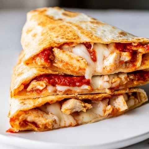 Golden-brown Tortilla Pizza Wrap with chicken, oozing mozzarella, ready to eat with a side.