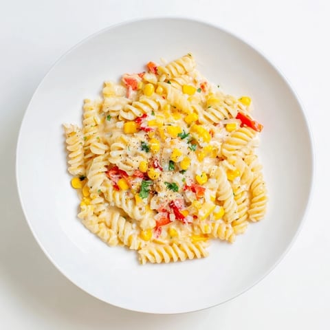 Close-up view of creamy One-Pot Mexican Street Corn Pasta, topped with fresh cilantro and cheese.