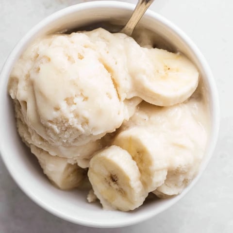 Freshly blended 2-Ingredient Banana Ice Cream, a vibrant, creamy dessert free of dairy or added sugars.