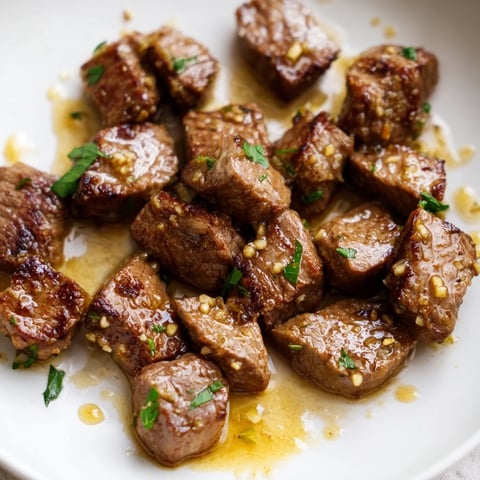 Tender air-fryer garlic-butter steak bites, glistening with sauce, ready to be served as an appetizer.