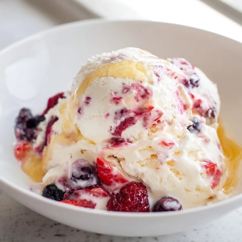 A bowl of Cottage Cheese Ice Cream, swirled with berries, ready for a cool treat.