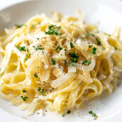 Golden, caramelized onions topping a bowl of warm One-Pot French Onion Pasta, ready to serve.