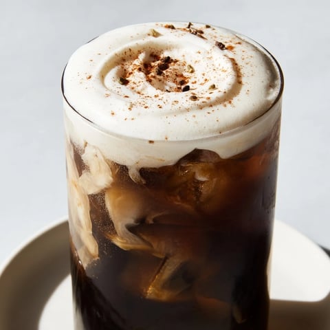 Homemade iced chai, a spiced tea beverage, topped with rich, creamy cold foam.