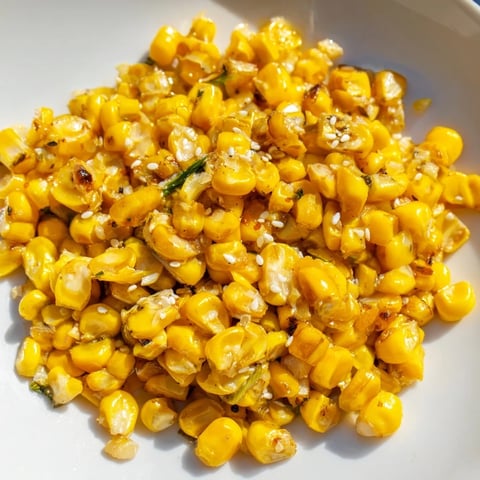 Vibrant golden Japanese Butter Corn, glistening and ready, garnished with scallions and sesame seeds.