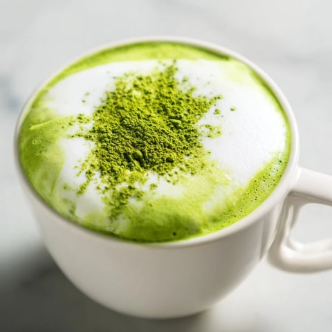 Steaming Matcha Green Tea Latte with frothy milk, perfect for a cozy afternoon treat.